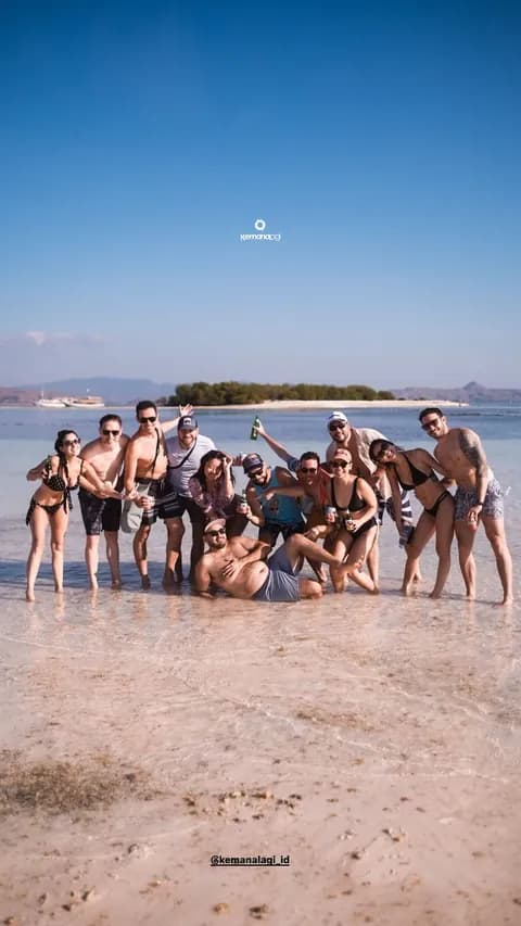 Group celebrating on a sandbar during a Sailing Komodo trip