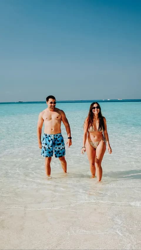 Couple wading in clear water at a Komodo white sand beach